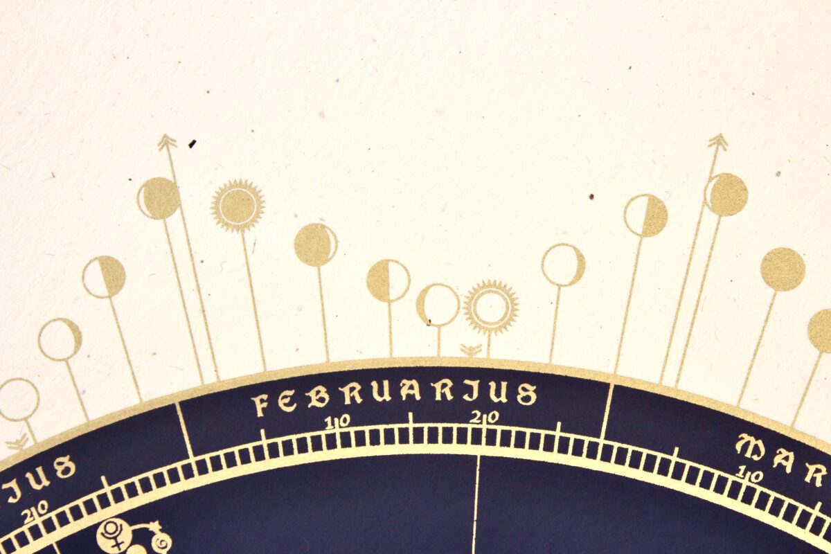 Close-up of gold screen-printed Moon phase symbols for February and March on the 2027 astronomical calendar.