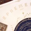 Detail of the Ephemeris 2027 title in golden ink above a circular celestial chart, showing lunar phases and decorative borders.